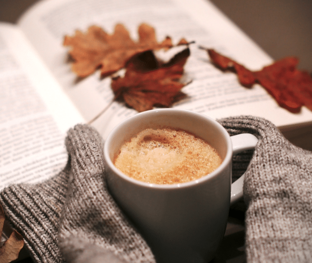 jesenna atmosfra kniha susene listy tepla kava ktoru drzia ruky vo svetri